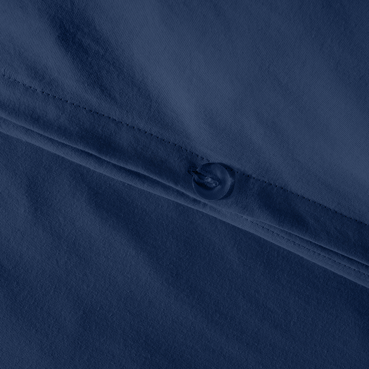 Closeup of navy blue Organic Cotton Jersey Duvet Cover Pillowcase Set fabric with snap button closure