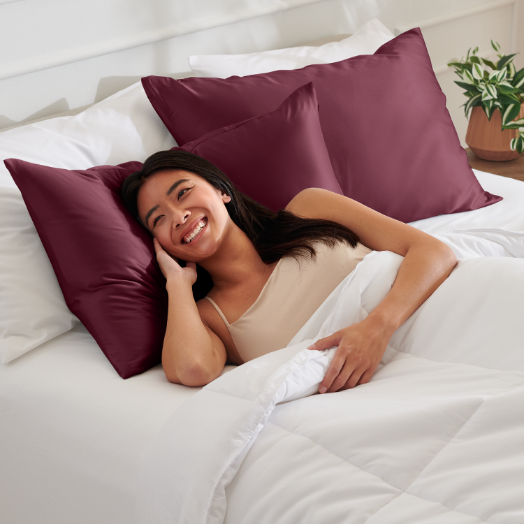 Woman lying on a burgundy satin pillow