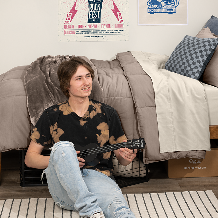 Woman sitting with olive green Ultimate Bed In A Bag