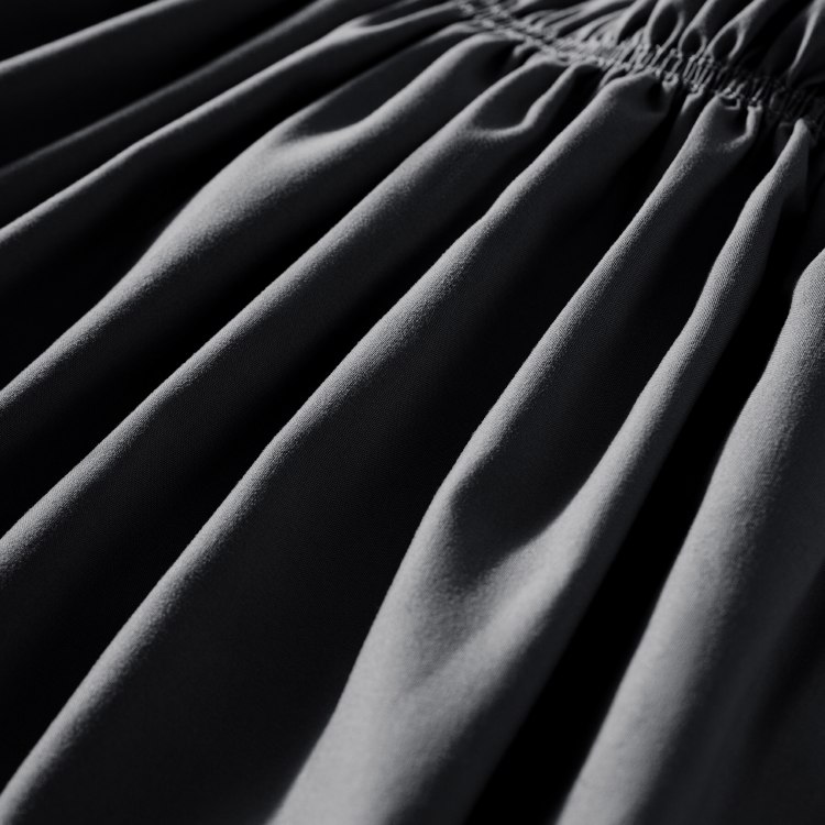 Close-up of pleated dark charcoal wrap-around bed skirt fabric