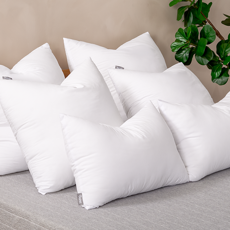Pillows with Pillow Inserts on a chair, plant nearby