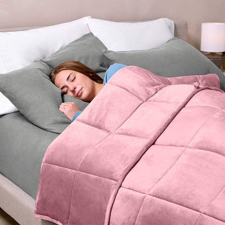 Close-up of a bed with a pink minky fleece weighted blanket