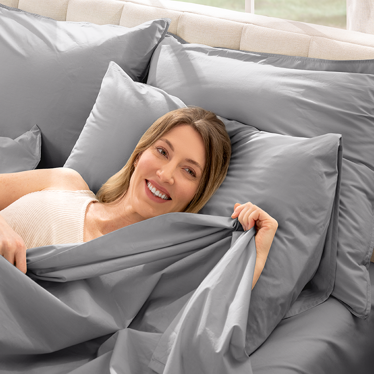 Woman resting on a pillow with gray Organic Cotton Percale Pillowcase Set