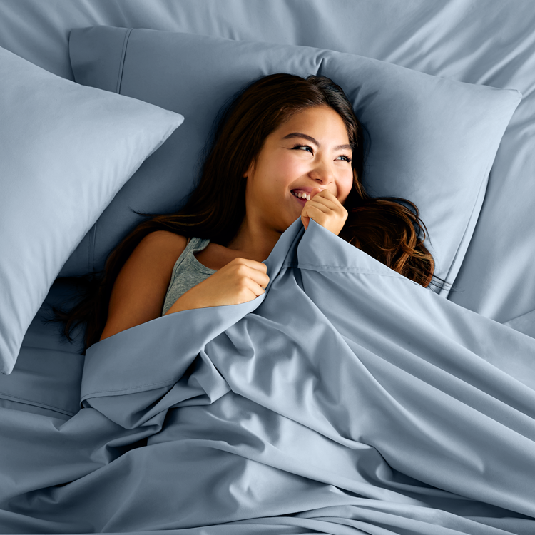 Woman in bed with blue Ultra Soft Neutrals Lights Sheet Set