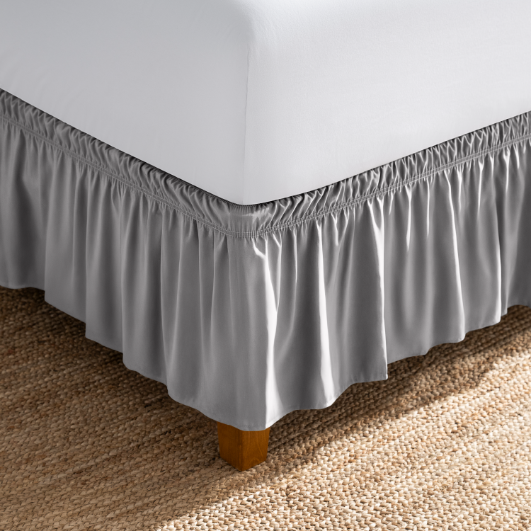 Bed with a dark gray wrap-around bed skirt