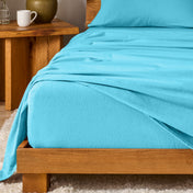 Bed with flannel bedding and wooden headboard and nightstand next to it.