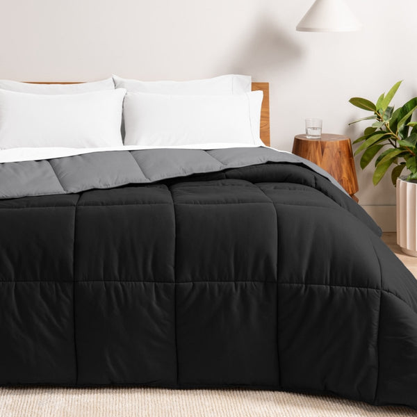 Bed with reversible comforter and white pillows in a bedroom setting