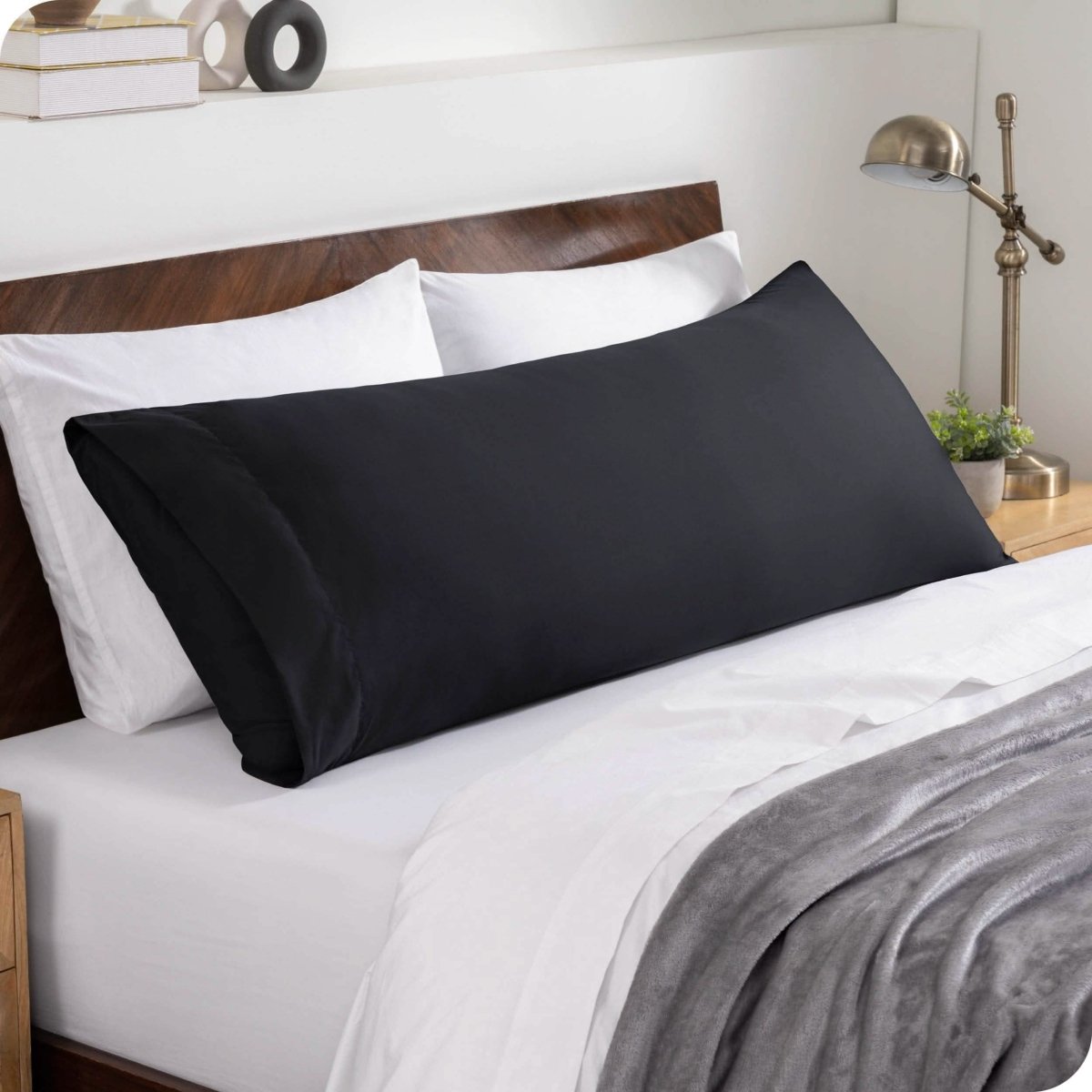 A body pillowcase on a pillow set against a headboard