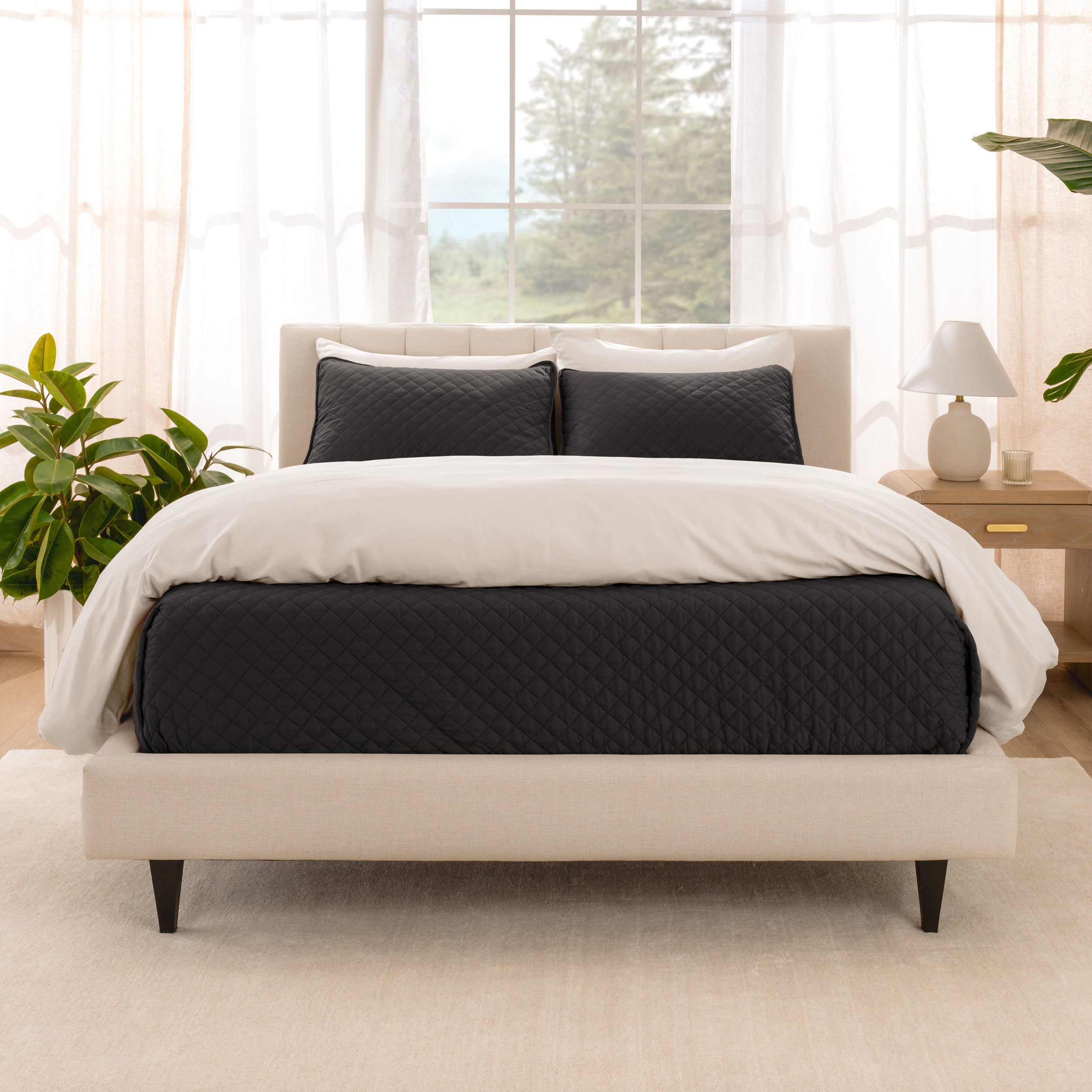 A bright bedroom with a coverlet set on the bed