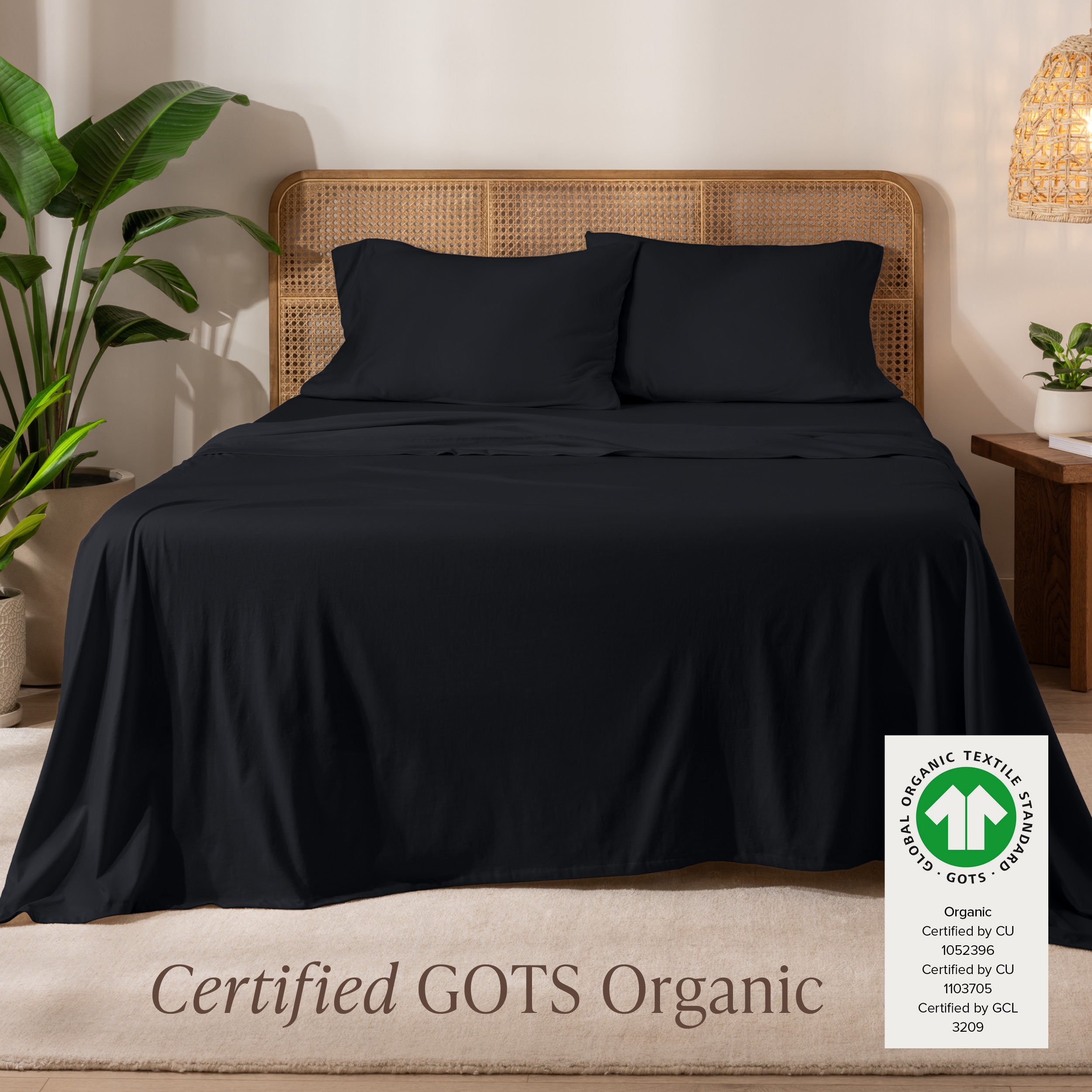 Jersey sheets on a bed with a wicker headboard in a room with plants and a lamp.
