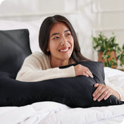 A woman is resting on a satin pillowcase covered pillow