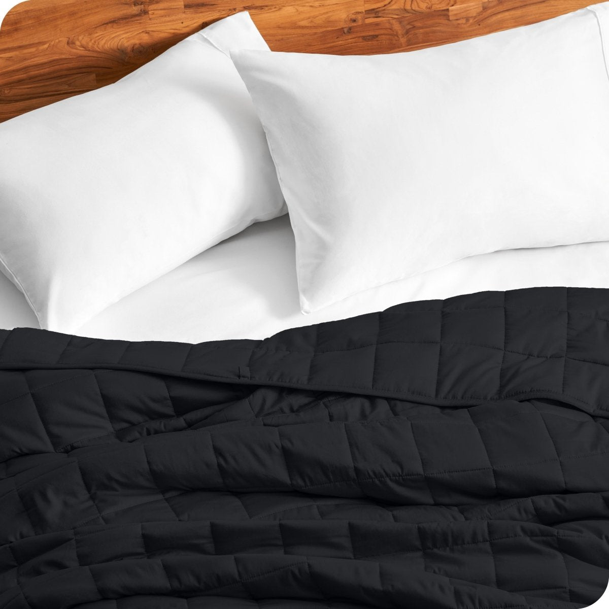 Close up of a weighted blanket on a bed next to pillows