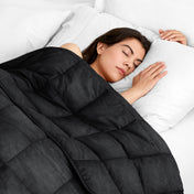 Woman sleeping peacefully under a weighted blanket with white pillows