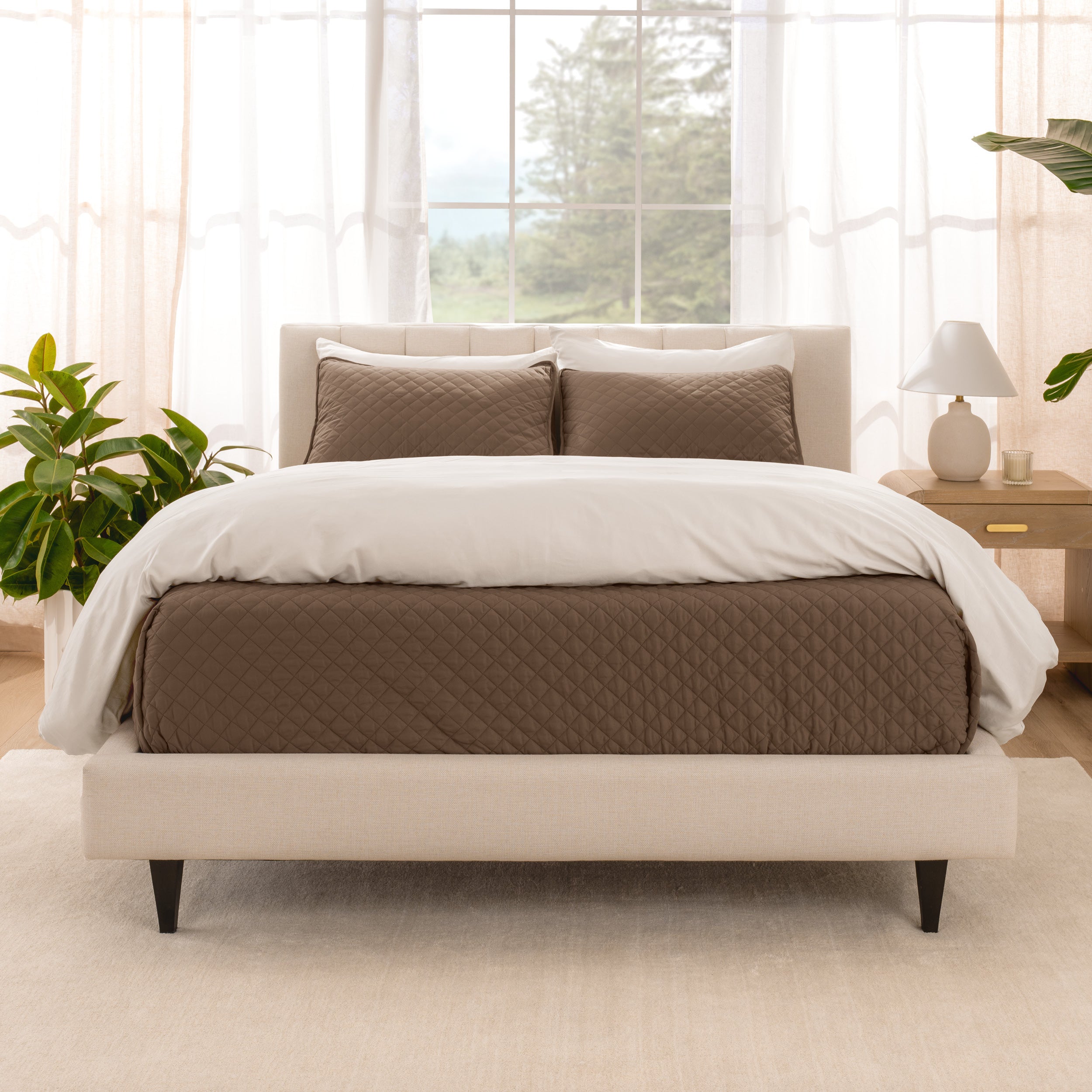 A bright bedroom with a coverlet set on the bed