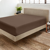 A side view of a bed made with a fitted sheet on it