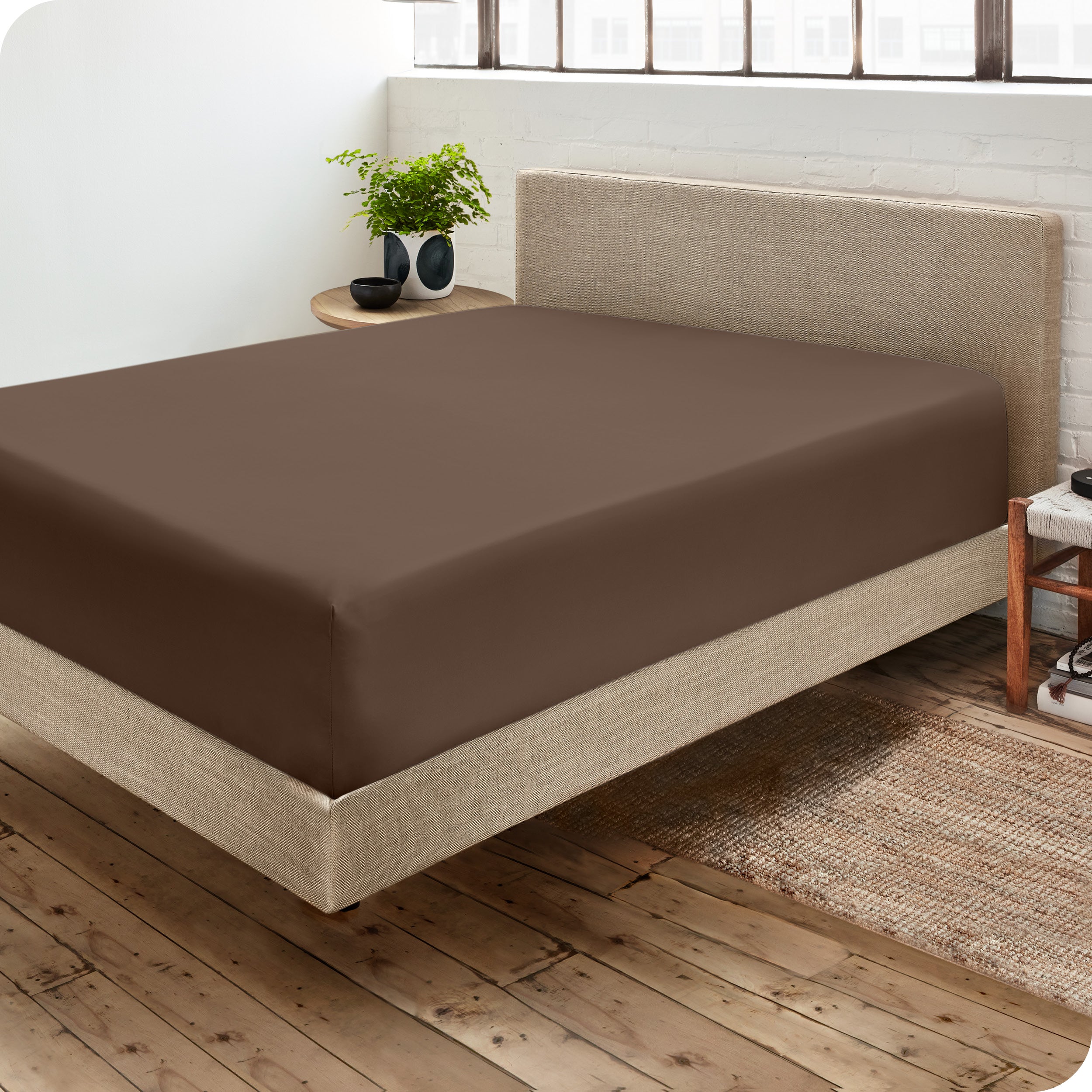 A side view of a bed made with a fitted sheet on it