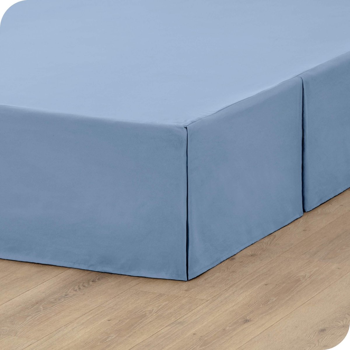 A box spring with a bed skirt on it