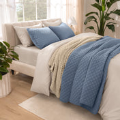 Side view of bed with coverlet set draped on a bed made with a duvet set