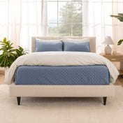 A bright bedroom with a coverlet set on the bed