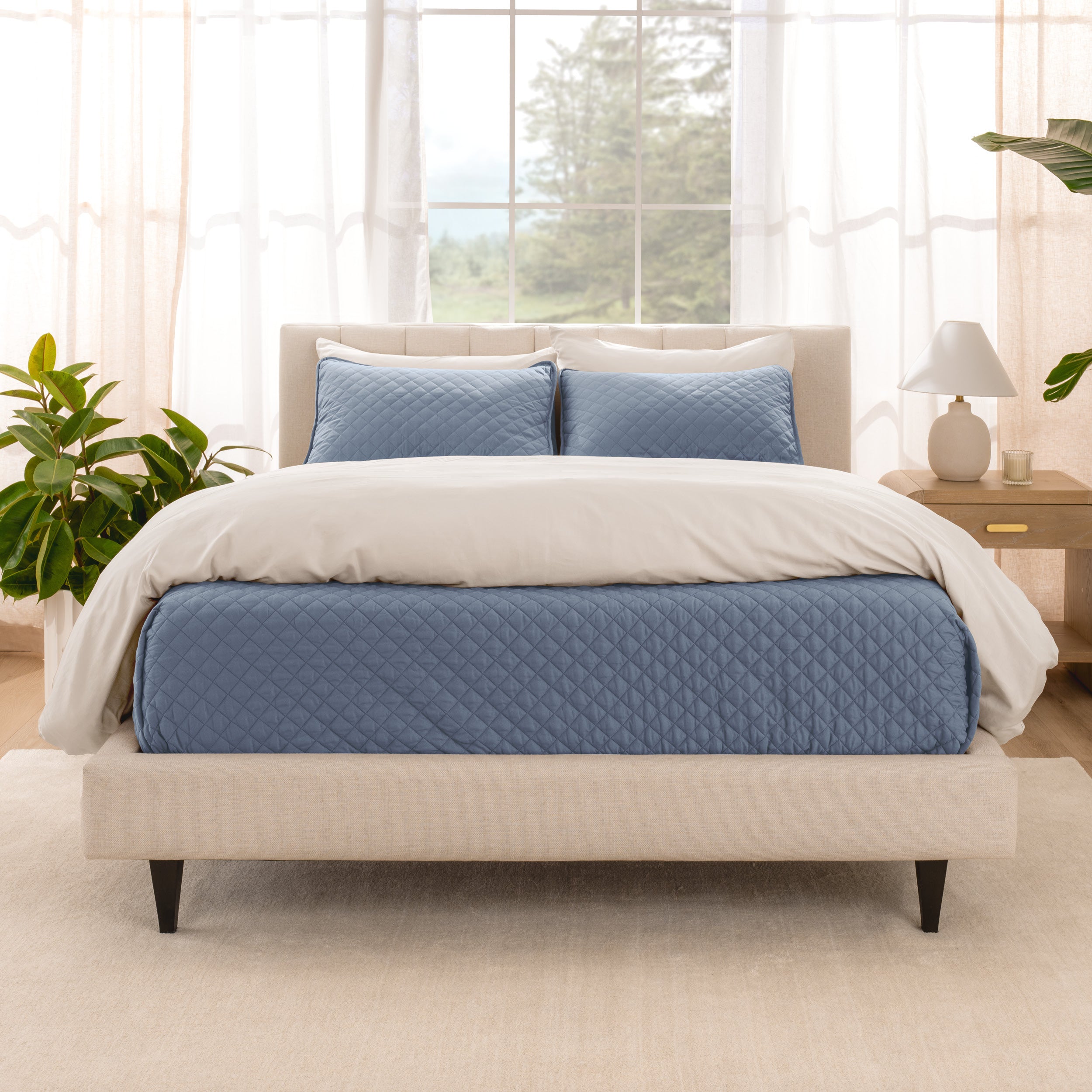 A bright bedroom with a coverlet set on the bed