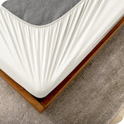 The corner of a box spring with a cover on it