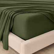 Fitted sheet and top sheet on a mattress with a beige bed frame