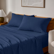 Cotton flannel sheets and pillows on a wooden bed in a bedroom setting.