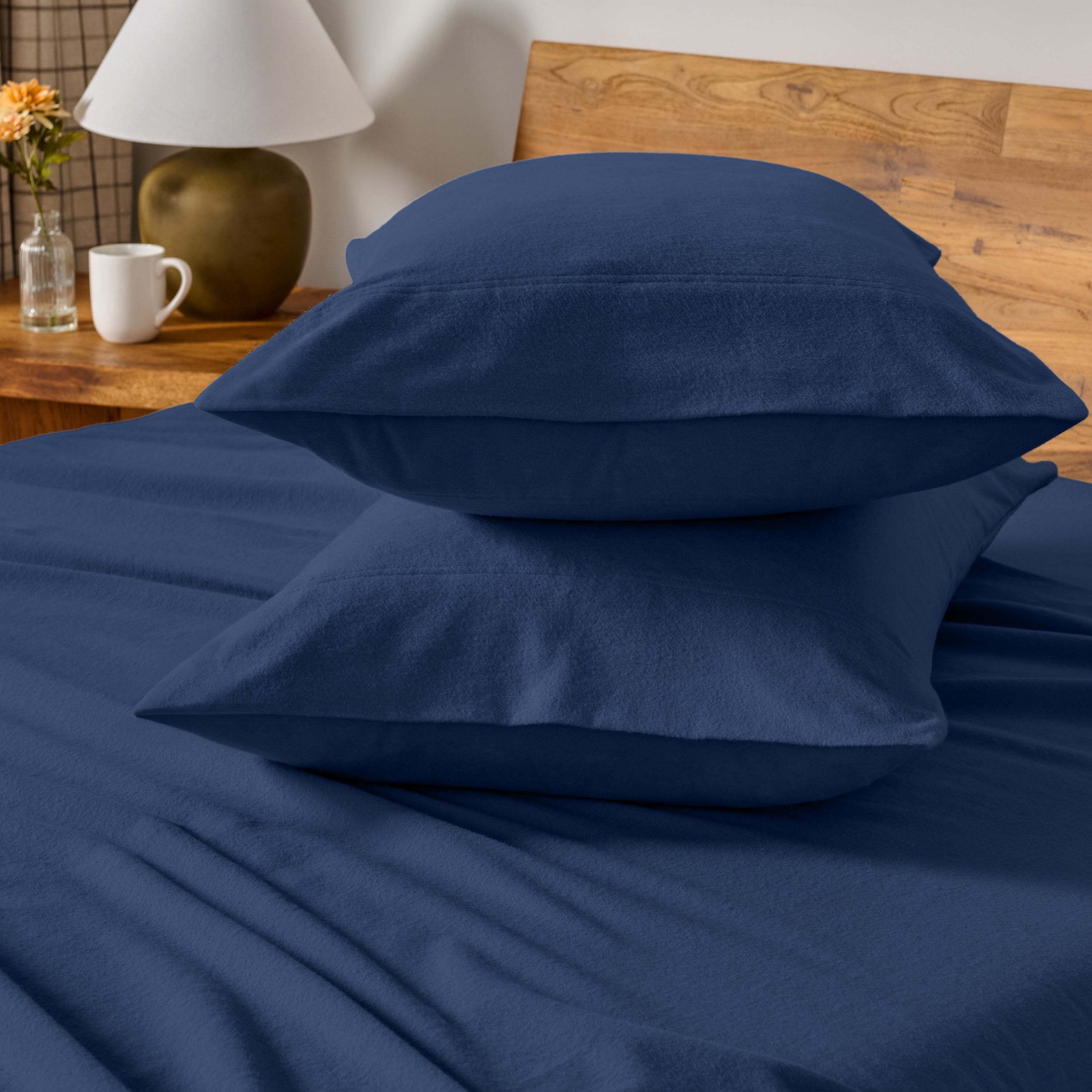 Flannel bedding set on a bed with a beige headboard and lamp.