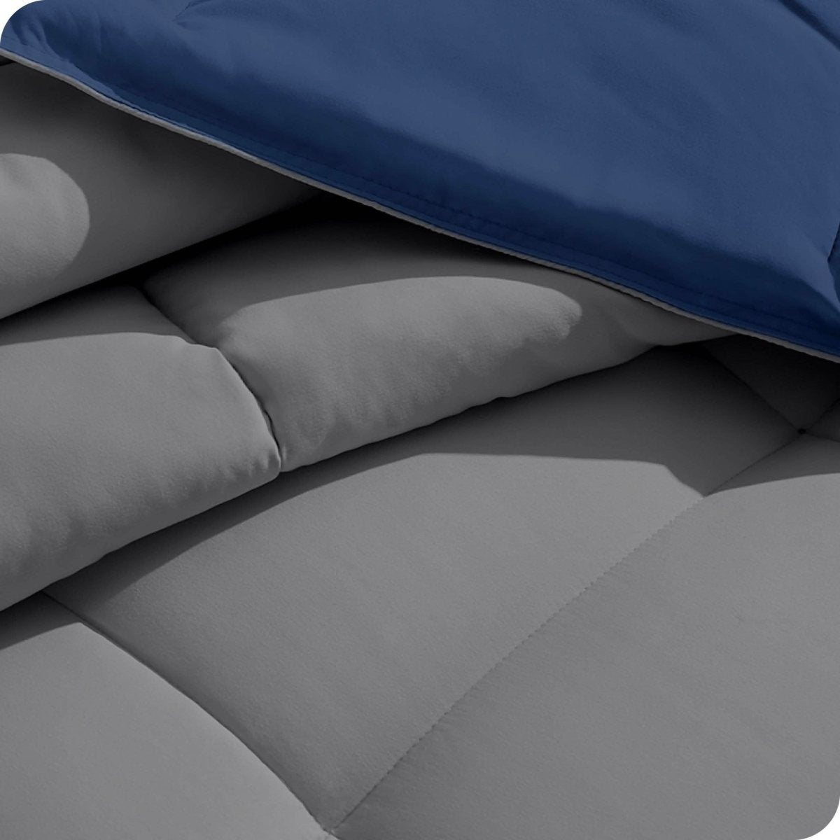 Close up of the reversible comforter showing the box stitching and the two colors