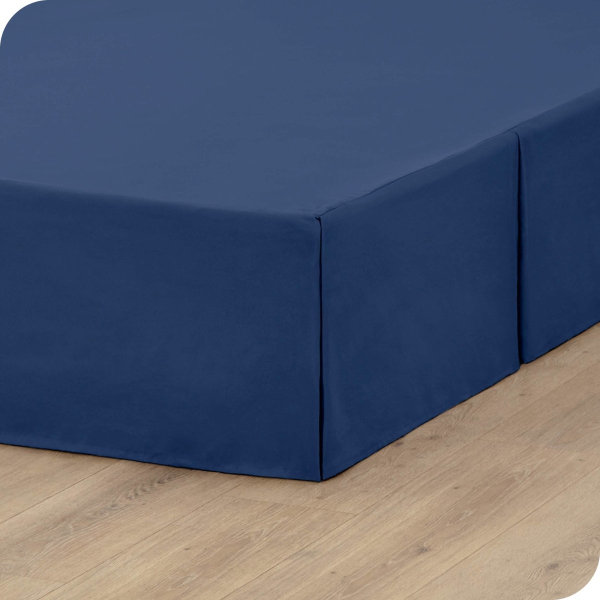A box spring with a bed skirt on it