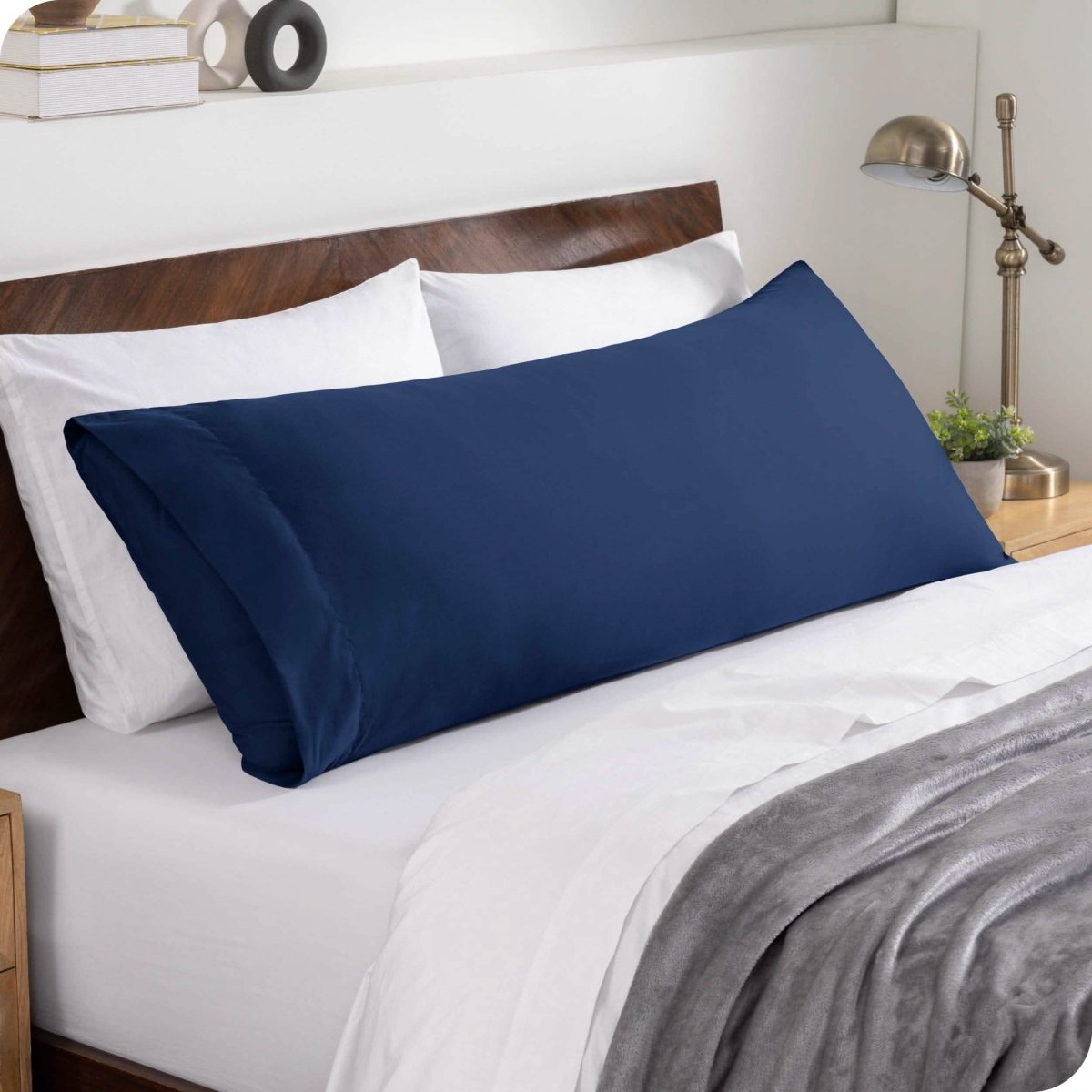 A body pillowcase on a pillow set against a headboard