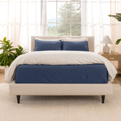 A bright bedroom with a coverlet set on the bed