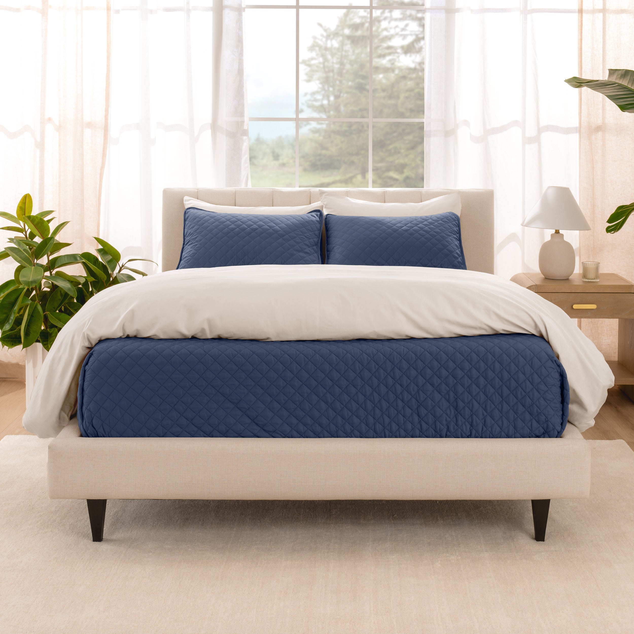 A bright bedroom with a coverlet set on the bed