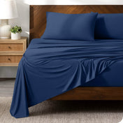 Dark Blue sheet set on a bed with a dark wooden bed frame