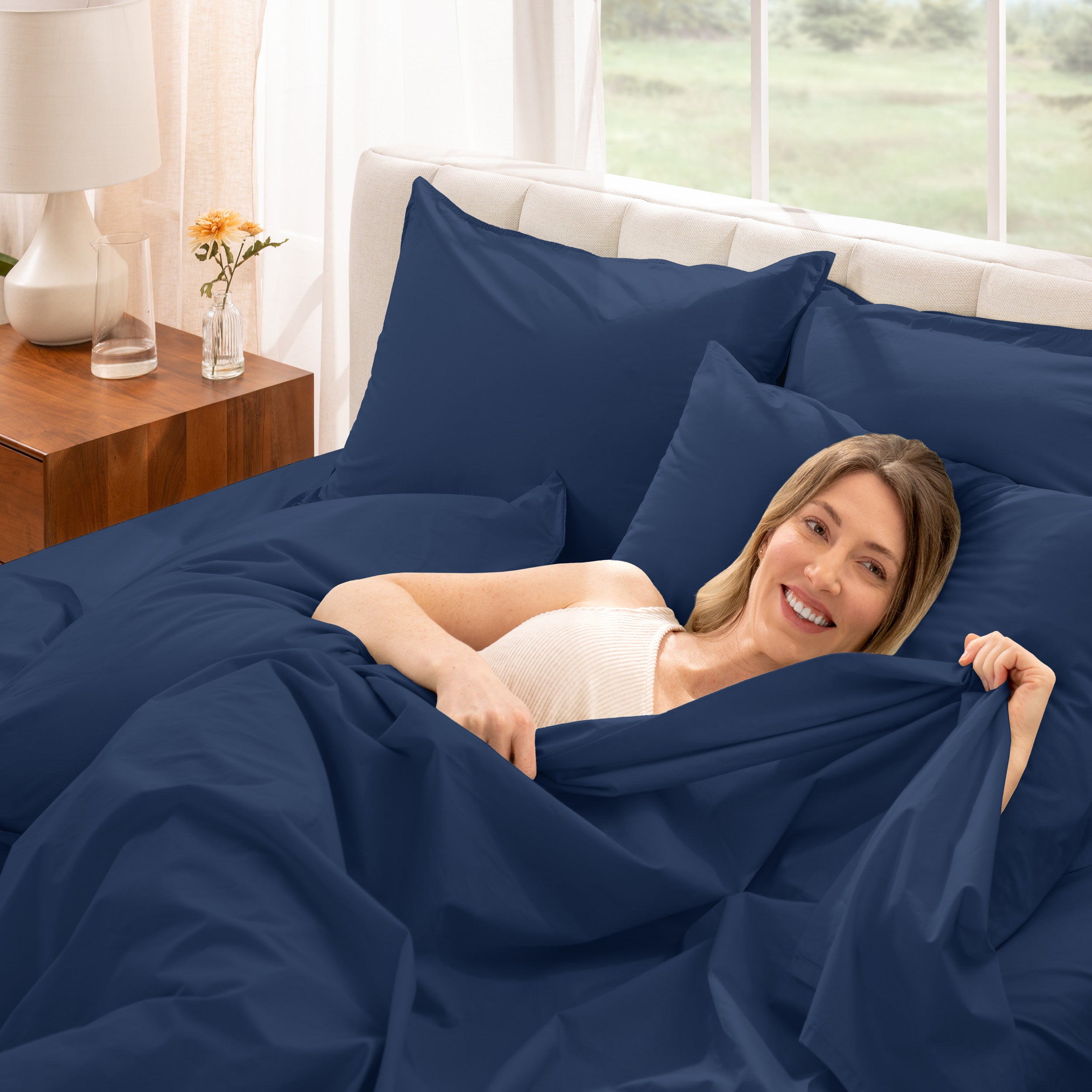 A woman is lying on a bed make with percale sheets and pillowcases