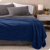 A double sided sherpa blanket on a bed