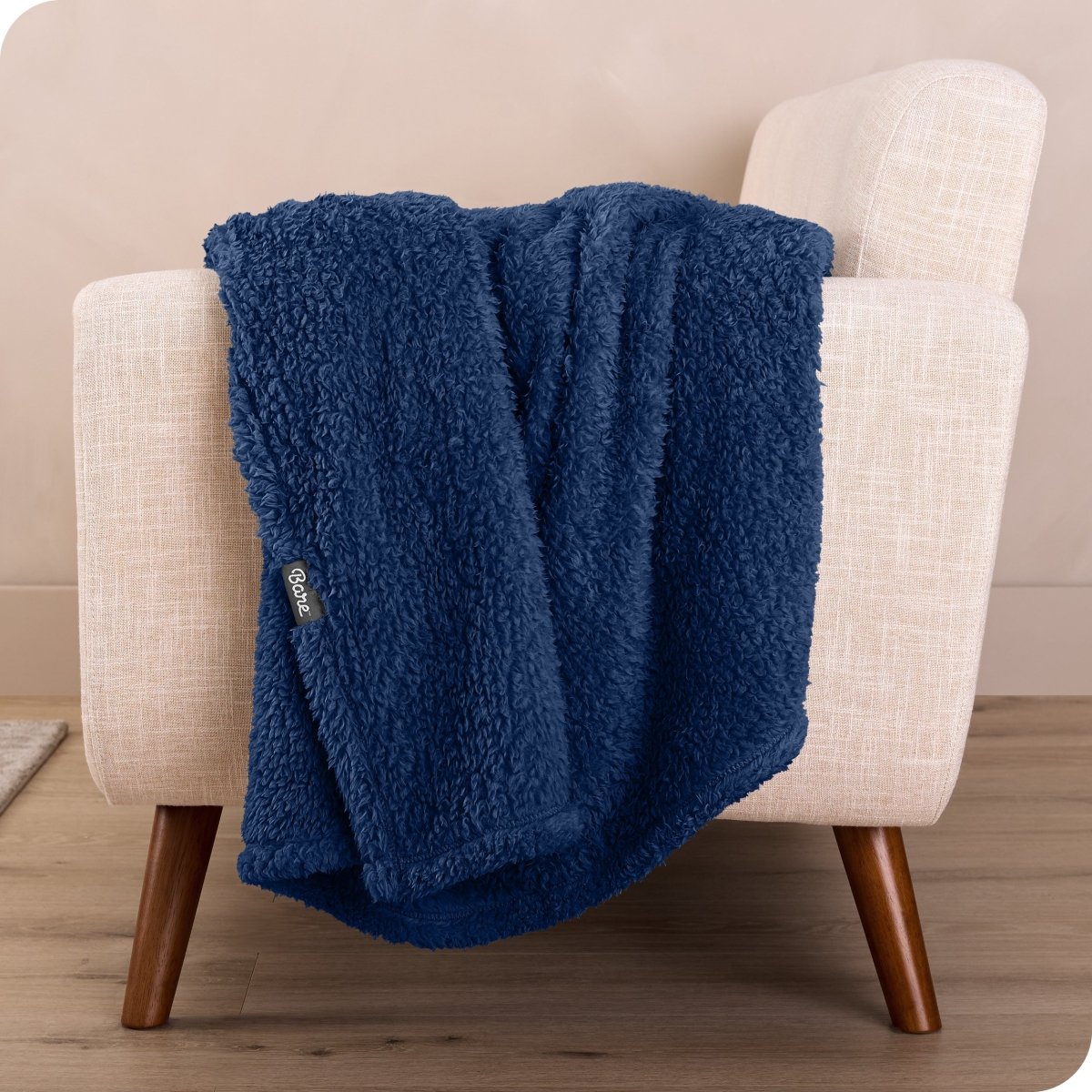 A sherpa blanket draped over a chair