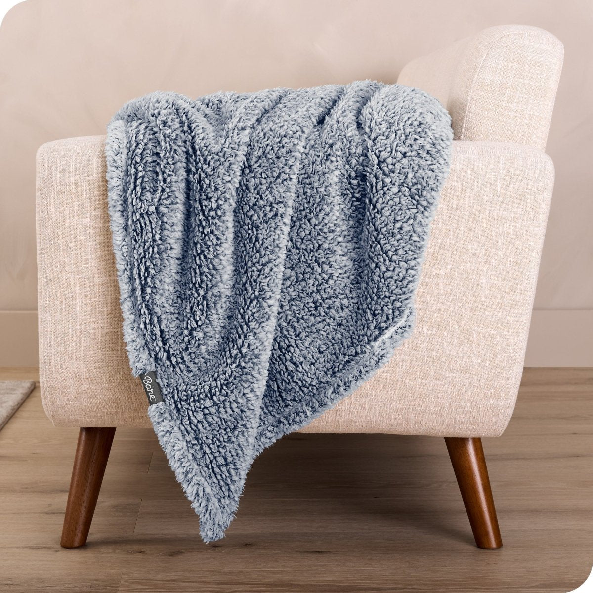 A sherpa blanket is hanging over the edge of a chair