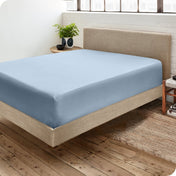 A side view of a bed made with a fitted sheet on it