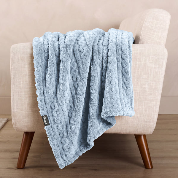 A textured blanket draped over a chair