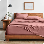 Modern bedroom with washed sheets draped over the end and the side of the bed
