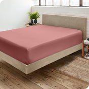 A side view of a bed made with a fitted sheet on it
