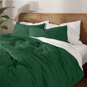 Bedding set on a bed with a wicker nightstand and lamp in a bedroom setting.