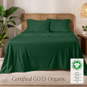 Jersey sheets on a bed with a wicker headboard in a room with plants and a lamp.