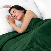 Woman sleeping peacefully under a weighted blanket with white pillows