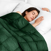 Woman sleeping peacefully under a weighted blanket with white pillows
