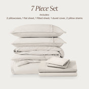 7-piece percale bedding set with pillowcases, flat sheet, fitted sheet, duvet cover, and pillow shams on a light background.