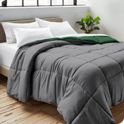 Close up of a comforter on a bed folded over itself. There are also 4 pillows on the bed.