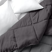 Close up of a comforter folded back to show the different colored sides
