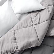 Close up of a comforter folded back to show the different colored sides